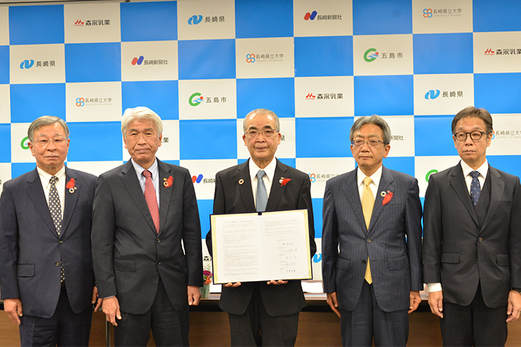 五島市、森永乳業、長崎県立大、長崎新聞社、長崎県の5者が並んだ写真