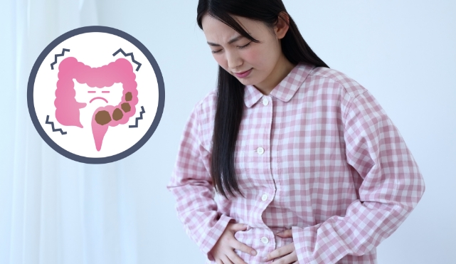 便秘でおなかが張って苦しい表情をした女性